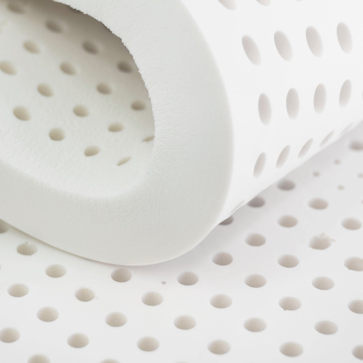 "Close-up of natural latex foam with circular holes"