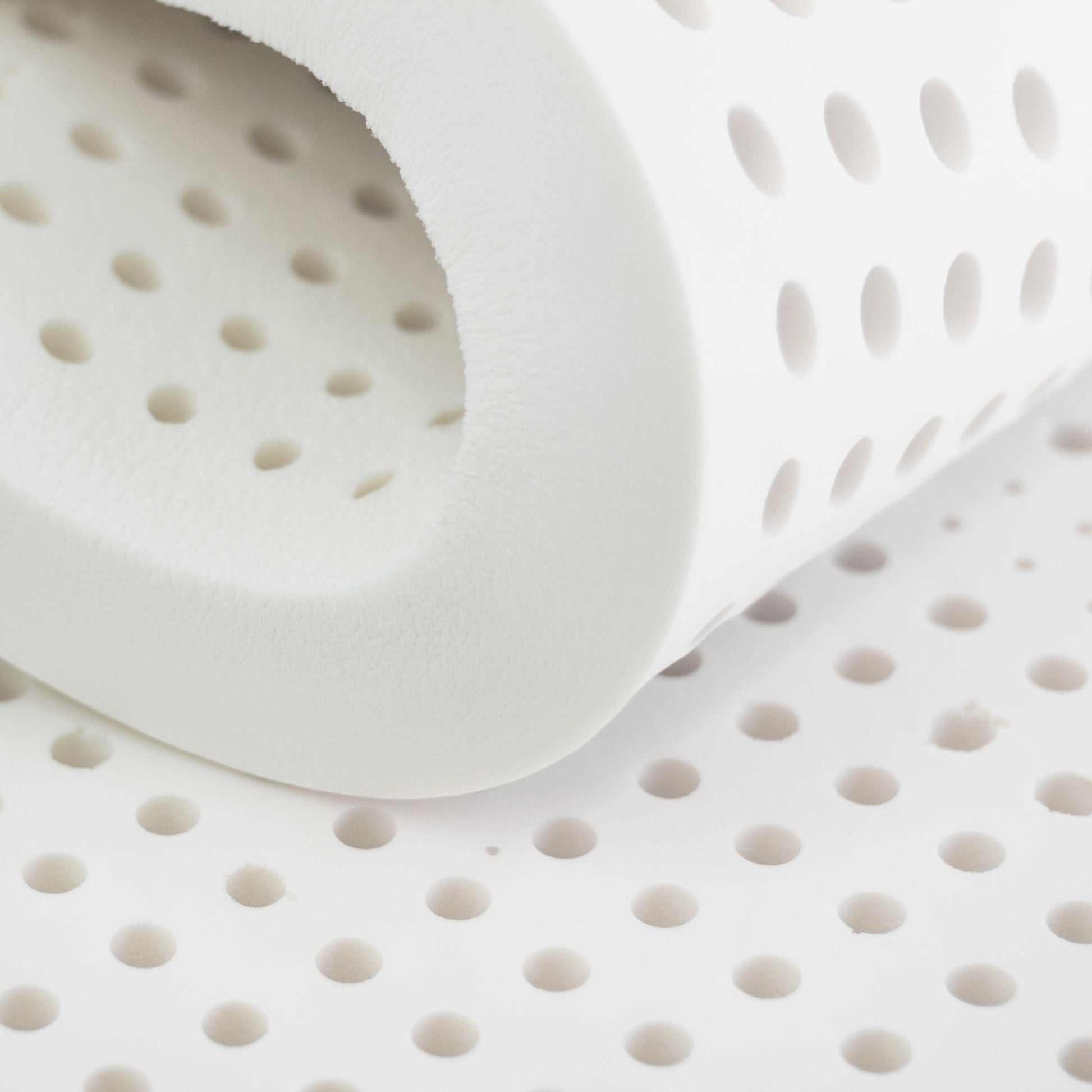 "Close-up of natural latex foam with circular holes"